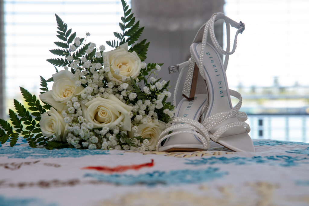 brides shoes and flowers laying on the bed